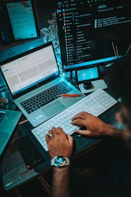 A person at a home office using a smartphone to analyze the stock market.